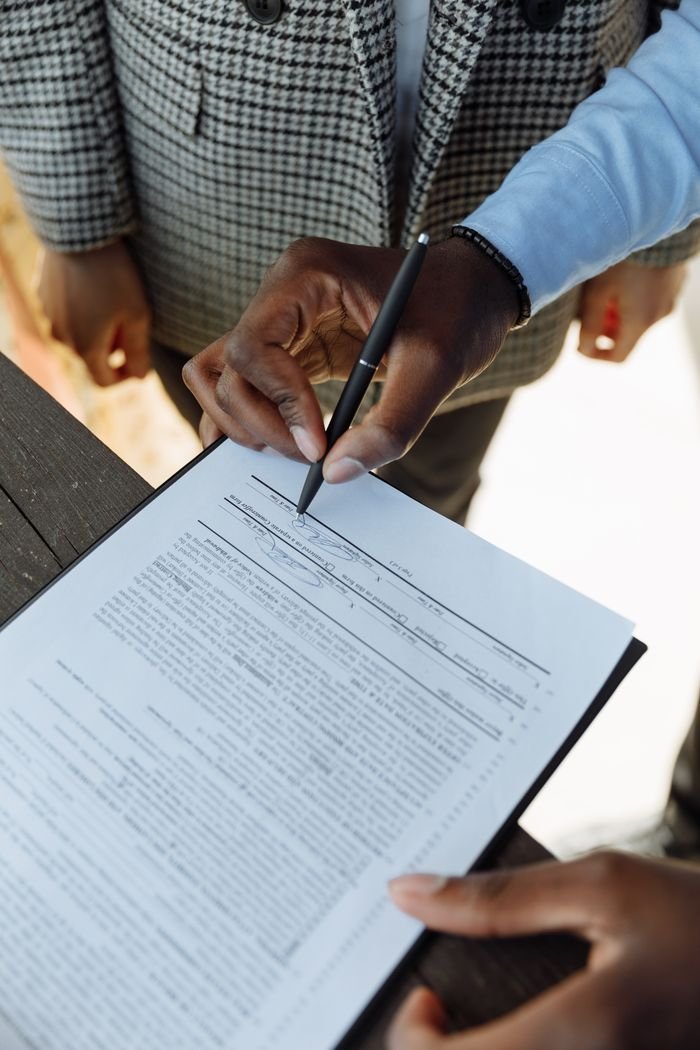 About Detailed view of a person signing a business contract with a pen, emphasizing agreement and ownership.